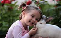 Meisje spelend met een wit konijn.Digra Photography